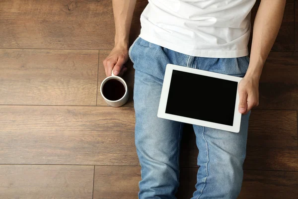 Человек с планшетом и чашкой кофе — стоковое фото