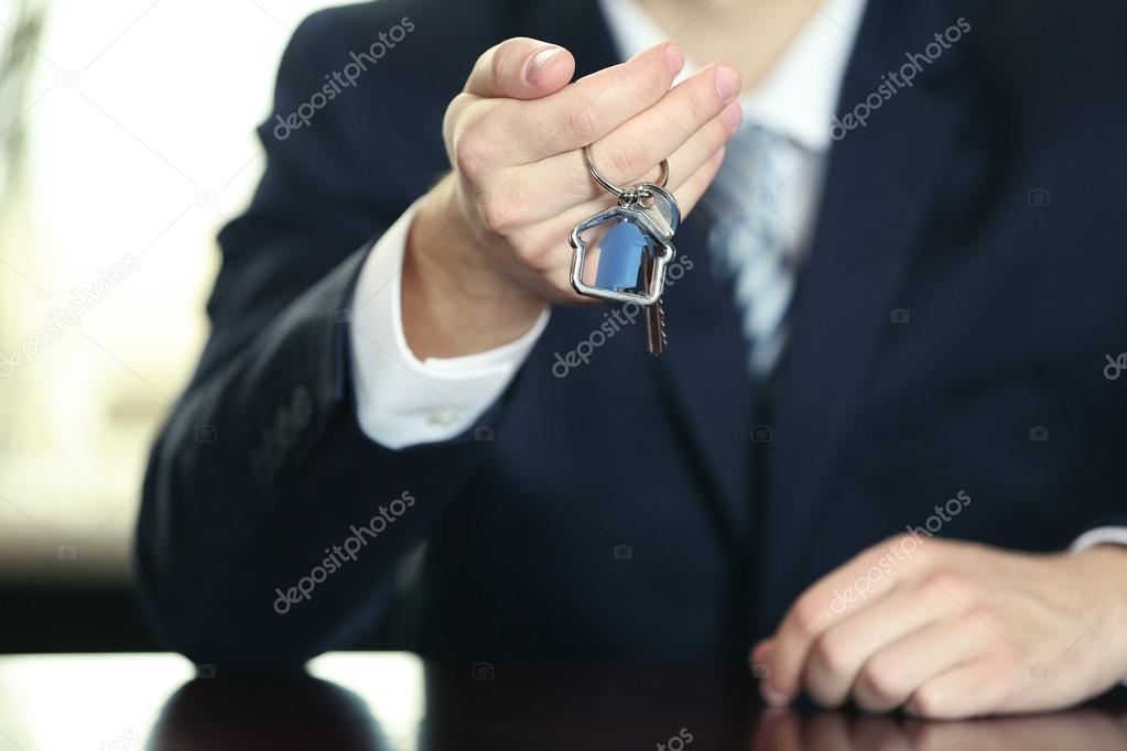 Businessman with keys in his hand in office
