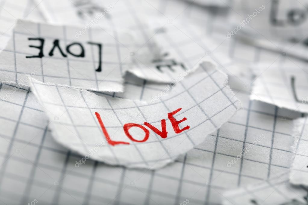 Word LOVE written on torn paper