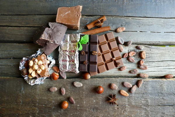 美味的巧克力与香料在木桌子上，特写 — 图库照片
