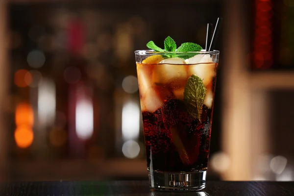 Glass of cocktail in bar on bright blurred background — Stock Photo, Image