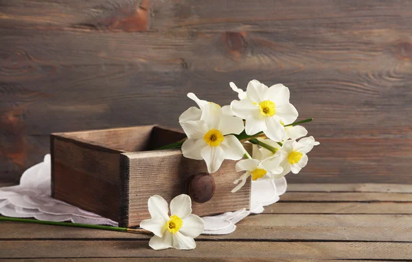 Narciso fresco en el pecho sobre fondo de madera — Foto de Stock