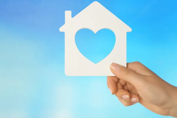 Female hand with model of house on color background — Stock Photo, Image