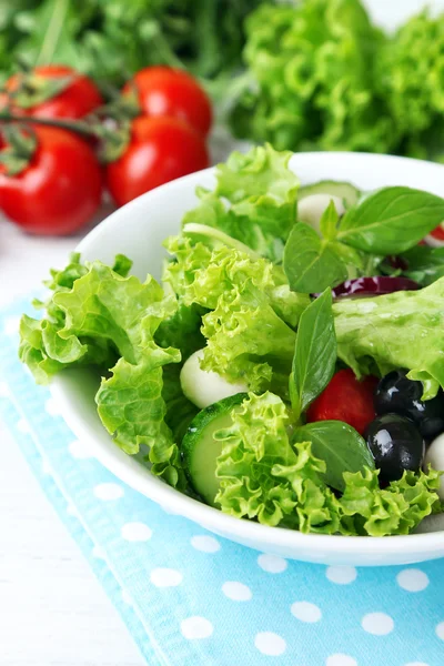 Färska grönsaker sallad i skål på bordet på nära håll — Stockfoto