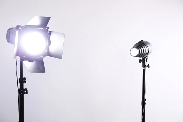 Estúdio de fotografia com equipamento de iluminação no fundo da parede branca — Fotografia de Stock