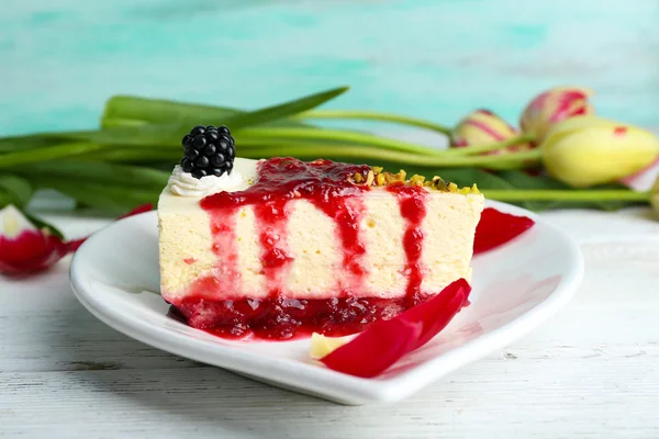 Lekker stukje cheesecake met berry saus op plaat op tafel close-up — Stockfoto