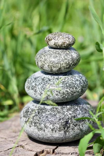 Stack of spa stones over green grass background — Stock Photo, Image