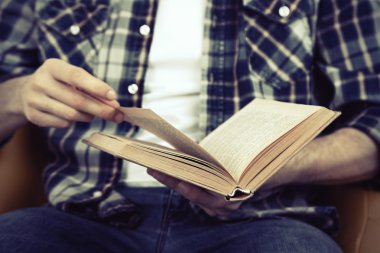 Genç adam kitap okuyor.
