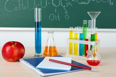 Kimya sınıfı test tüpleri üzerinde yeşil tahta arka plan ile Danışma