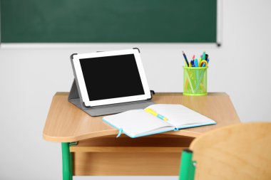 İleti örneği ve yazı tahtası arka plan üzerinde sınıfta tablet ile ahşap masa