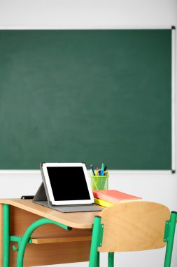 İleti örneği ve yazı tahtası arka plan üzerinde sınıfta tablet ile ahşap masa