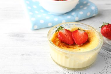 Creme brulee tatlısı peçeteye renk ahşap arka plan üzerinde taze çilek Çilek ile