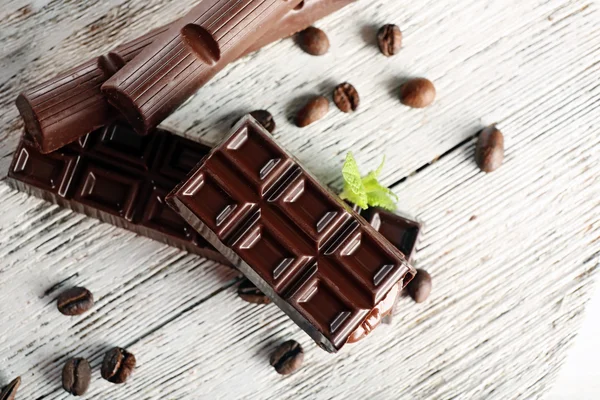 Stuffed chocolate with coffee beans and mint on wooden table, top view — Stock fotografie