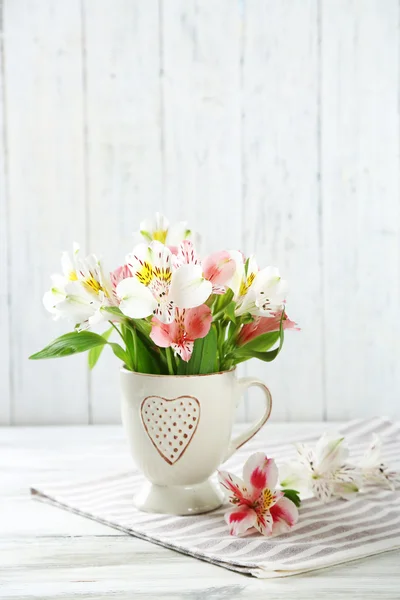 木製の背景上のカップの美しい花 — ストック写真