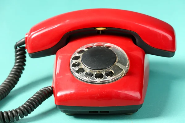 Telefono rosso retrò sul tavolo su sfondo verde — Foto Stock