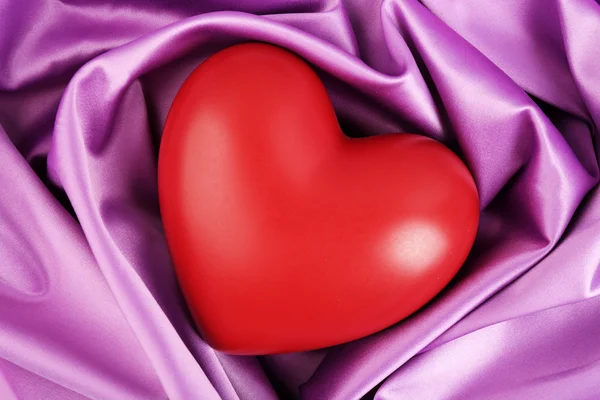 Красное сердце на фоне ткани — стоковое фото