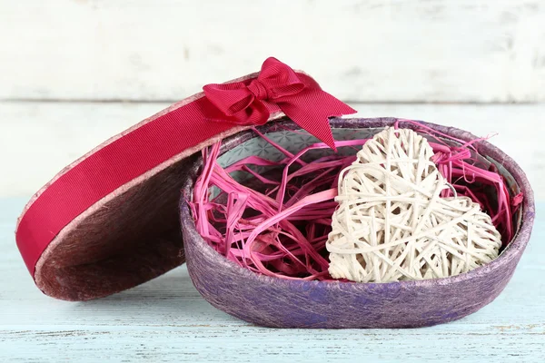 Wicker heart in present box on wooden table — Stock Photo, Image