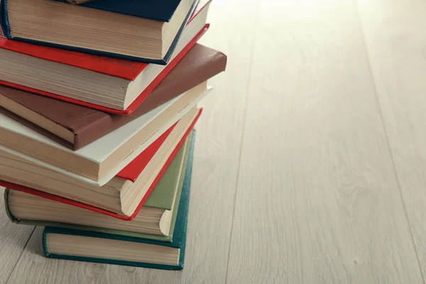 Pila de libros sobre fondo de madera —  Fotos de Stock