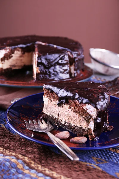 Deliziosa torta al cioccolato con glassa in piatto sul tavolo, primo piano — Foto Stock