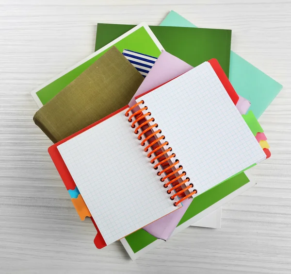 Laptop op de top van stapel boeken en tijdschriften op houten achtergrond — Stockfoto