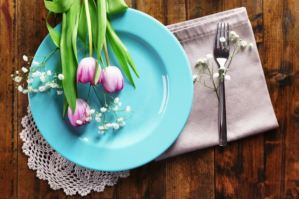 Vajilla con flores en la mesa — Foto de Stock