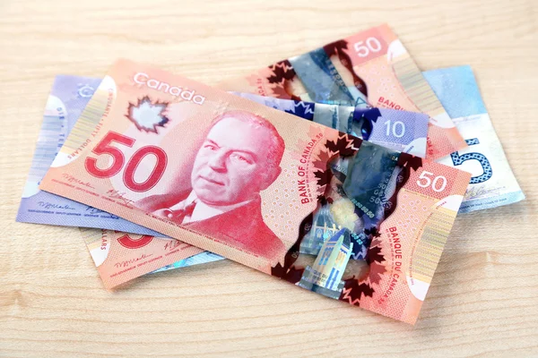 Canadian dollars on wooden table — Stock Photo, Image