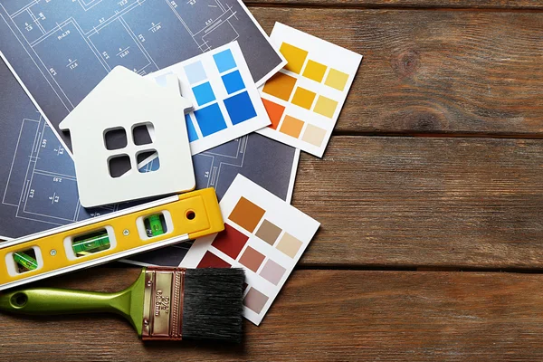 Muestras de color, casa decorativa, guantes y pinceles — Foto de Stock