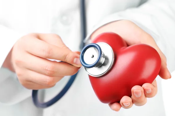 Doktor eliyle stetoskop ve kırmızı kalp, portre — Stok fotoğraf