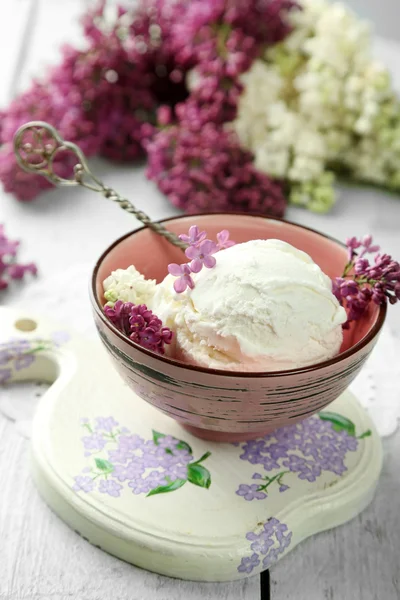Beautiful composition with tasty ice cream and lilac flowers — Stock Photo, Image