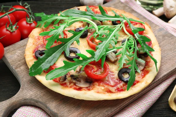 Pizza gustoasă cu legume și arugula pe masa de tăiere aproape — Fotografie, imagine de stoc