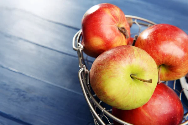 Dojrzałe jabłka w metalowy kosz na drewniane tła — Zdjęcie stockowe