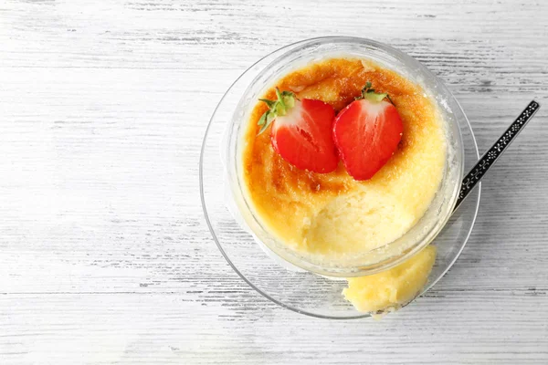 Creme brulee dessert with fresh strawberry berries on napkin, on color wooden background — Stock Photo, Image