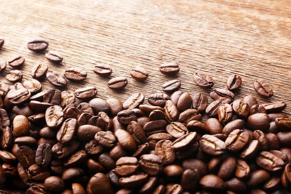 Granos de café sobre fondo de madera — Foto de Stock