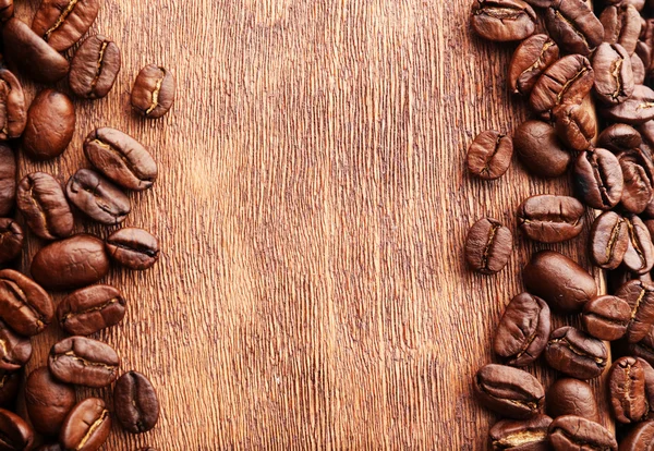 Grãos de café em fundo de madeira — Fotografia de Stock