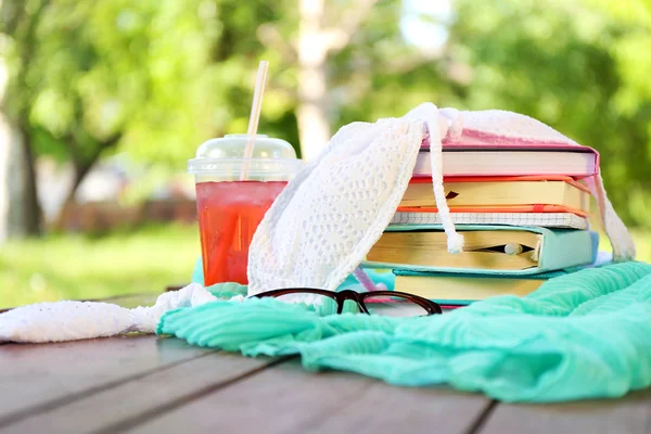Böcker, glasögon, baddräkt och dryck utomhus — Stockfoto
