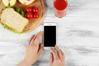Gıda ve eller içinde hareket eden telefon