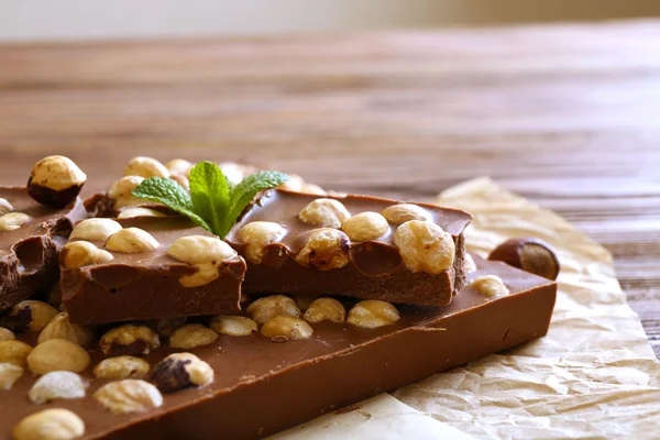 Chocolate con nueces en pergamino, primer plano —  Fotos de Stock
