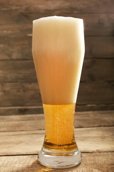 Sklenice piva na dřevěném pozadí — Stock fotografie