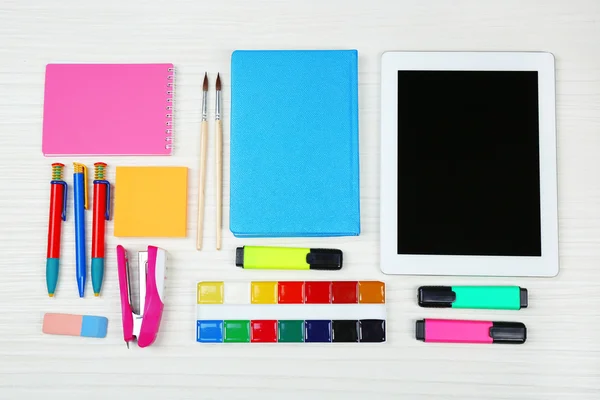 Digital tablet with stationery on wooden background — Stock Photo, Image