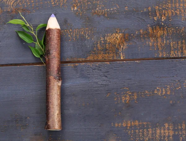 Lápis de madeira com folha sobre fundo de madeira — Fotografia de Stock