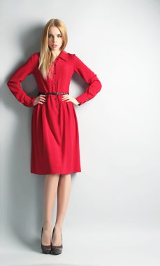 Etkileyici genç model gri arka plan üzerinde Kırmızı elbiseli