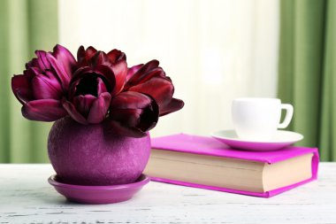 Kumaş arka plan üzerinde kitap ile tencerede güzel Lale