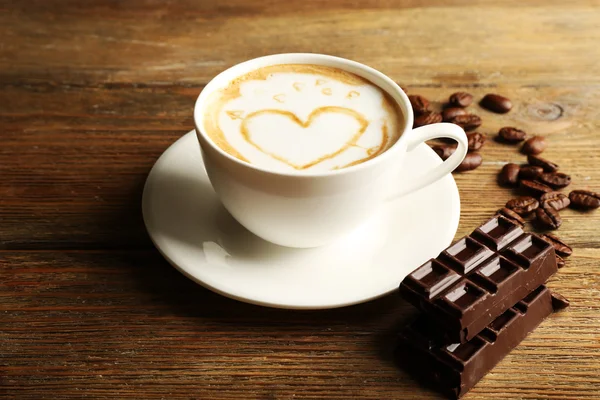 Taza de café con leche arte con granos y chocolate — Foto de Stock