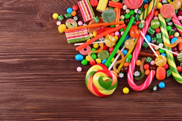 Doces coloridos em fundo de madeira — Fotografia de Stock