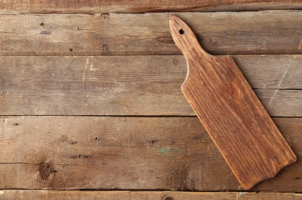 Cutting board on wooden background — Stock Photo, Image