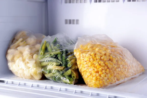 Frozen vegetables in bags in freezer close up — Stock Photo, Image