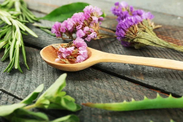 Groene kruiden en bladeren op houten tafel, close-up — Stockfoto