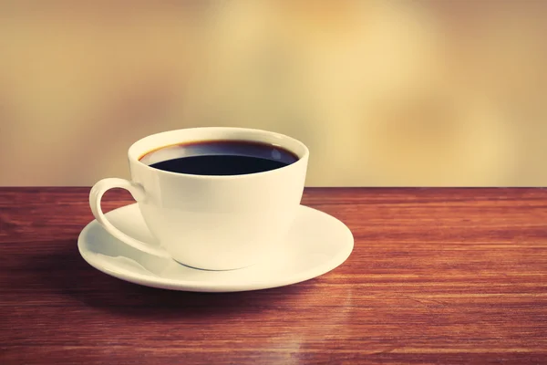 Taza de café en la mesa sobre fondo brillante — Foto de Stock