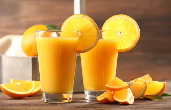 Jugo de naranja sobre mesa sobre fondo de madera — Foto de Stock