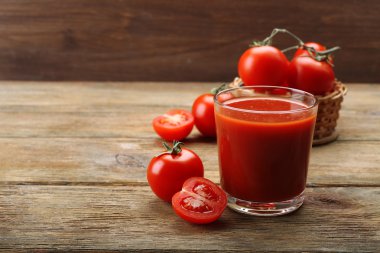 Bardak taze domates suyu ahşap arka plan üzerinde